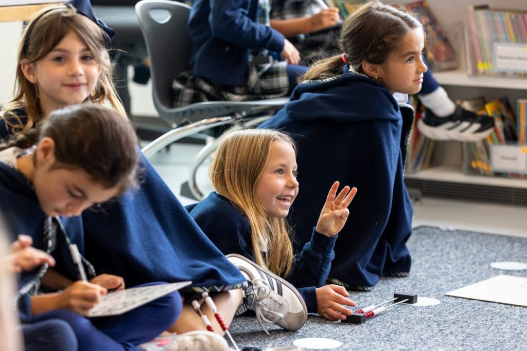 Student smiling and holding up the number three