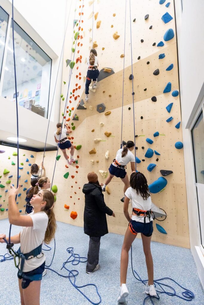 Students preparing to climb on climbing wall
